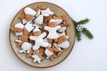 Decorated gingerbread cookies of various shapes on a plate. Christmas baking