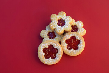 Linzer cookies on a red background, flowers and round shape. Homemade baking