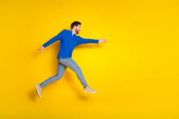 Fototapeta na wymiar Full body photo of attractive young man fast running have fun dressed stylish blue clothes isolated on yellow color background