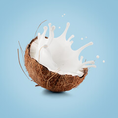 coconut with palm leaf and milk splash on a light blue background