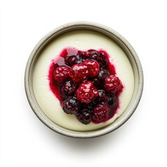 A delicate dessert sits on a simple plate, adorned with an enticing mixture of fresh raspberries and dark berries, creating a delightful contrast against a pristine background