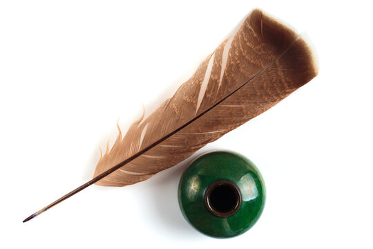 Feather and old green inkwell isolated on white background. Feather for calligraphy, old education, vintage fonts. Top view.