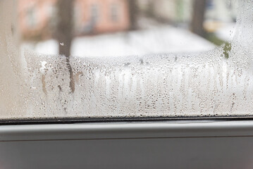 Steamy window in the apartment due to moisture and poor ventilation....