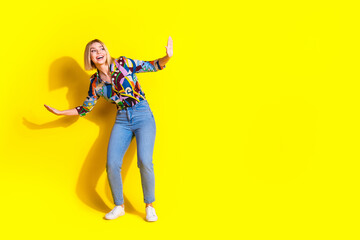 Full size photo of pretty young girl surfing have fun wear trendy colorful outfit isolated on yellow color background