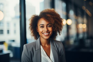 Fototapeta premium Smiling portrait of a young African American businesswoman in modern office