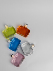 multi-colored bottles with liquid for ultrasonic aromas lie on a gray background, flat lay.