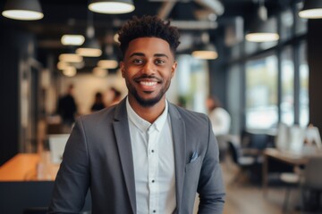 Obraz premium Smiling portrait of a young African American businessman in modern office