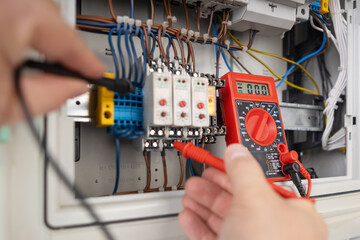 Hands Testing Electrical Circuits with Multimeter