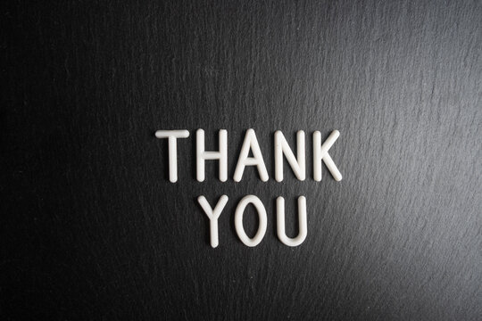Thank you text on black background. Top view. Copy space.