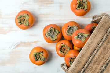 Delicious fresh persimmon fruits on wooden table.