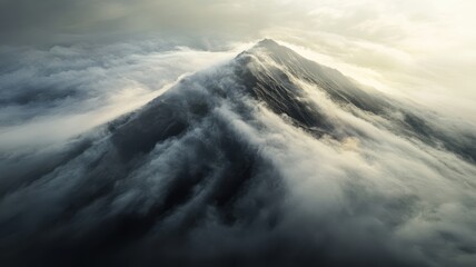 Naklejka premium A dramatic mountain peak emerges from swirling clouds, creating a majestic and mysterious atmosphere.