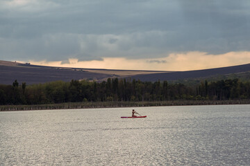 Beautiful lake Tambukan, Caucasus. Person paddling a sup