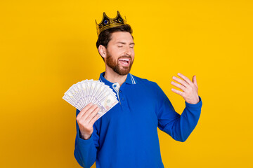 Photo portrait of attractive young man hold money fan king dressed stylish blue clothes isolated on yellow color background