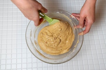 Pastry chef mixing ingredients in glass bowl with spatula