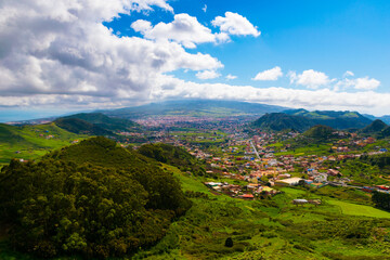 View of San Cristobal de la Laguna and El Teide mountain in the clouds from Anaga Rural park, Tenerife, Canary island, Spain © Anyarnia
