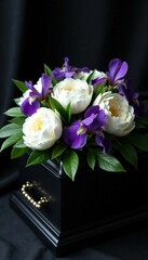 White peonies and purple irises in black casket, mourning, sophisticated, black casket © Withun