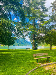 Fototapeta premium Crone public park with empty benches on Lake Idro, Lombardy, Italy. Empty lakefront with beach of the small Crone village. Tourist resort in Brescia province, Lombardy.