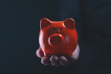 hand holding piggy money with red heart. saving and save money concept.