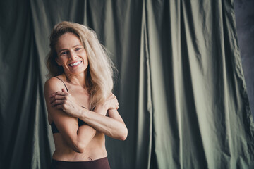 No filter studio photo of sweet pretty woman wear lingerie embracing loving herself isolated khaki textile background