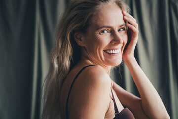 Obraz premium Studio no retouch photo of positive good mood lady dressed lingerie accepting her age isolated khaki textile background