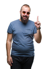 Fototapeta premium Young caucasian hipster man wearing sunglasses over isolated background pointing finger up with successful idea. Exited and happy. Number one.