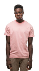 Fototapeta premium Young african american man wearing pink t-shirt puffing cheeks with funny face. Mouth inflated with air, crazy expression.
