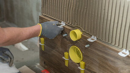 Tiling work using the leveling system. Inserting a leveling clip before laying the next tile.