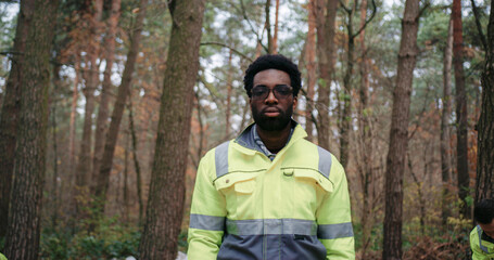 Close up Portrait of bearded African American male with glasses. Wearing gloves and warm clothing....