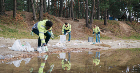 Community showing action aimed at combating plastic pollution at beach of small pond or lake....