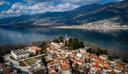 Old town and mosque in aerial take of Ioannina, Greece. Lake and mountains