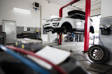 Car on hydraulic lift in modern auto repair shop