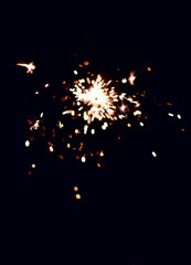 Obraz premium Festive sparks from a sparkler on a black background