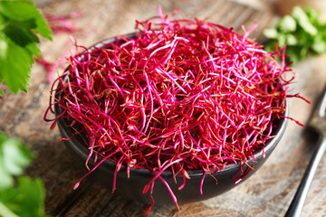 Fresh red beet sprouts or microgreens in a bowl on a table