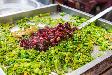Cairo, Egypt, Africa. Street vendor cooking green peppers and meat.