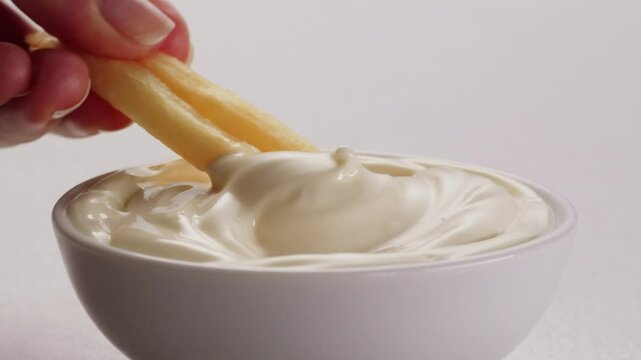Pouring mayo white creamy sauce close-up in cafe restaurant. Cooking fast food fries with mayonaise sauce. Fast and junk food concept.