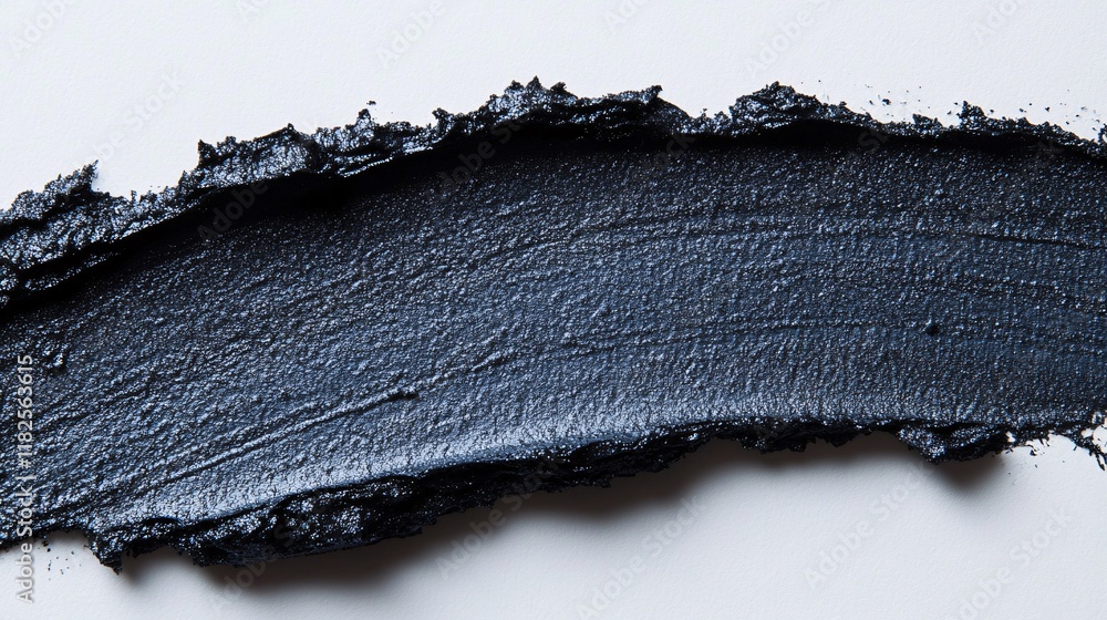 Poster black paint spread across a clean surface with a textured finish showing depth
