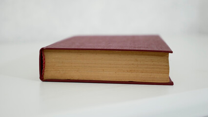 An old hardback book  on a white table