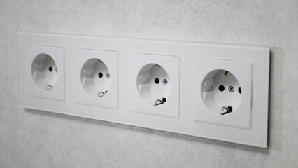 Four empty European wall outlets