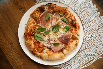 Delicious full ham pizza served on outdoor restaurant table, close-up food photography of Italian cuisine meal