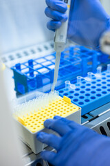 Scientist using a micropipette dropping liquid into a micro test tube during medical research in a...