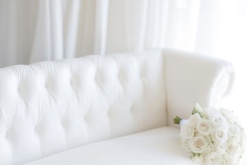 A bouquet of white roses placed on a white couch, great for decoration or as a still life photography prop