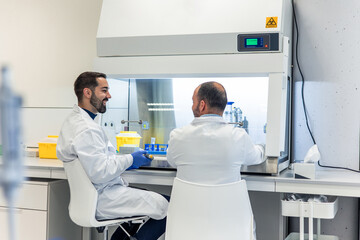 Two male scientists smiling and working together in modern laboratory