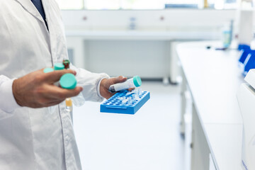 Scientist holding test tubes and rack in laboratory