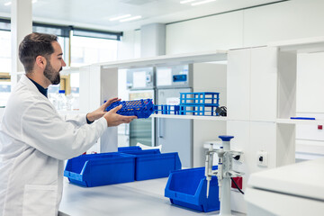 Scientist organizing laboratory material on shelves in modern laboratory