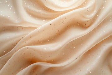 Obraz premium Smooth beige silk fabric flows gently, adorned with golden glitter, creating a luxurious and elegant textile background