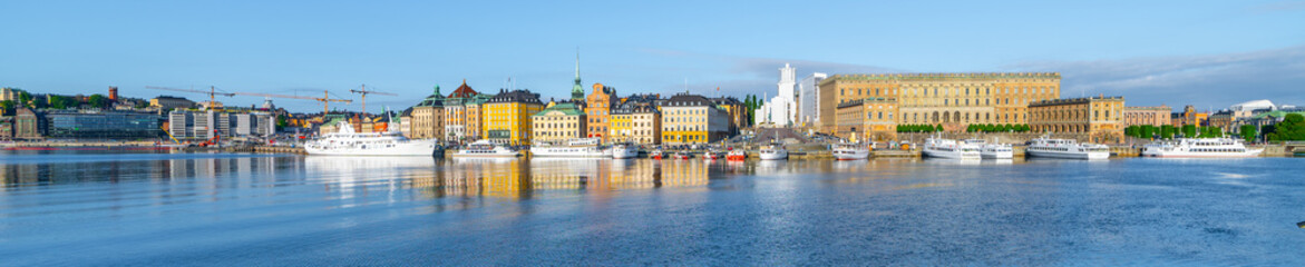 The Stockholm waterfront basks in the evening light, featuring the grandeur of the Royal Palace and the city reflection on the tranquil water. Stockholm, Sweden
