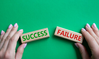 Success or Failure symbol. Concept word Success or Failure on wooden blocks. Businessman hand. Beautiful green background. Business and Success or Failure concept. Copy space