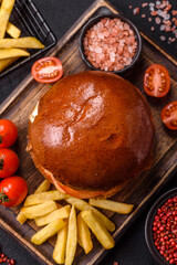 Delicious burger with beef patty, fried egg, bacon, herbs, sauce, salt and spices
