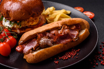 Delicious juicy hot dog with sausage, bacon, sauce, salt and spices