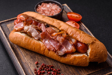 Delicious juicy hot dog with sausage, bacon, sauce, salt and spices